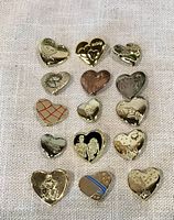 All fifteen gold-tone heart pins laid out on fabric