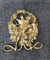 Front view of sterling silver Cupid and wreath brooch