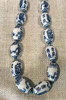 Close view of ceramic beads showing painted characters and fish