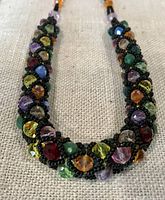 full view of necklace showing braided design and multi-color faceted beads