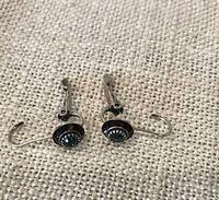 Both earrings front view on fabric background