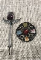 Both brooches side by side on fabric background