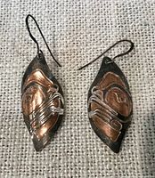 Front view of both earrings showing copper and silver Indigenous design
