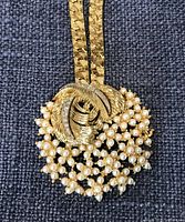 Close-up of pendant front showing faux pearls and rhinestones