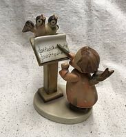 Full view showing angel conducting birds at music stand