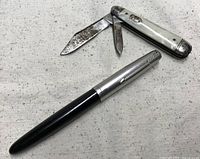 Parker 51 pen alongside two-blade MOP pocket knife, blades open