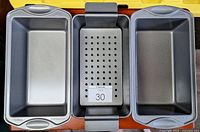 Top view of three grey loaf pans including perforated tray insert