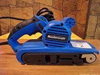 Left side view of Mastercraft belt sander showing body, belt track and label