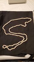 Full view of 25.5 in continuous bead necklace laid out showing length and colour