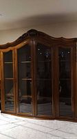 glass-front hutch with carved crest and glass doors