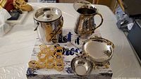 Full set showing ice bucket with lid, pitcher, tongs, snack bowl with attached garnish bowl, and ten napkin rings