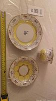cup, saucer and plate shown with tape measure for scale