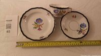 Overall view of the three-piece Meissen tea set with measuring tape for scale