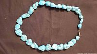 Full view of turquoise nugget necklace laid flat
