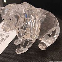 Front view of faceted crystal grizzly bear figurine showing head, body, black eyes and nose