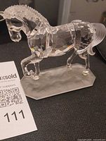 Three-quarter front view of crystal horse on frosted base