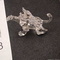 Front angle of crystal lion cub showing raised paw and facial details