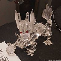 Front three-quarter view showing red eyes, frosted whiskers and tail, faceted crystal ball under paw