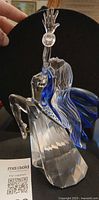 Front angle of Swarovski Isadora figurine showing clear crystal body and blue scarf
