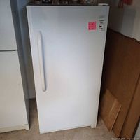 Front view of white upright freezer showing full door and handle