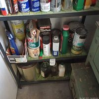 Shelving unit holding assorted paint cans, spray cans, solvent bottles and cleaners