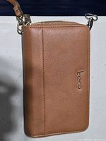 Front view of tan Bizou zip-around wallet with wrist strap