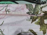Front view of pink camouflage handbag showing exterior zip pocket and fabric pattern