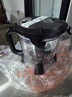 Side view of clear Ninja pitcher with black lid and handle in original plastic