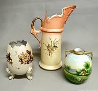Three ceramic pieces: tall floral pitcher, cracked egg vase, round Nippon vase
