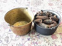 Brass cauldron left, cast iron cauldron right filled with pine cones