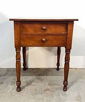 Full view of table front showing two drawers and turned legs