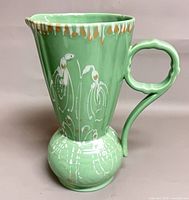 Profile view showing body, decoration, handle