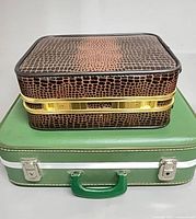 Green suitcase and brown barware case stacked