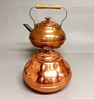 Teapot stacked on lidded container showing overall form and finishes