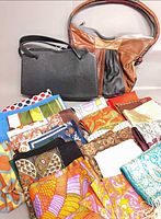 Group shot of two handbags with stacked scarves