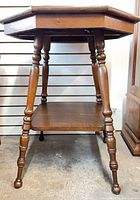 Side view of oak octagonal table showing turned legs and lower shelf
