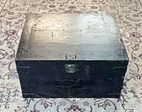 Closed black pine trunk front view showing latch and wear