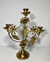 Front view of brass candelabra with three arms and floral decorations