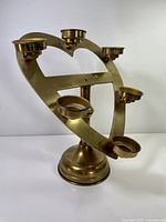 Front view of brass heart-shaped votive candle stand with five cups