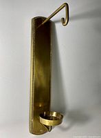 Full view of brass wall sconce showing hook, backplate, and candle cup