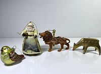 Group shot of four ornaments: Santa, lion, bird, deer