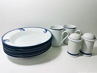 Stacked soup bowls, mugs, salt and pepper shakers