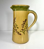 Full side view of jug showing shape, handle, spout and decoration