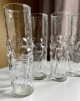Four clear highball glasses with applied male and female figures
