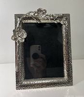 Front view of hammered metal frame with orchid motif