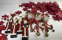 Group shot of five wooden Santas, eleven red wooden stars, and tangled red straw star garland