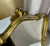 Top detail of gilded scroll crest