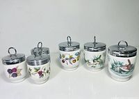 Group shot of all five Royal Worcester egg coddlers showing size variation and motifs