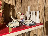 Shelf with 2 Bradford Exchange plates, jam jar, swan figurine, four milk glass vases