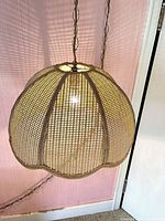 Single lit wicker swag lamp showing shape and weave